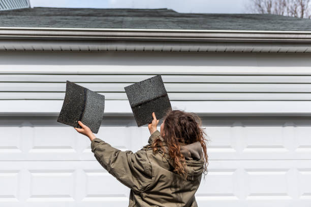 Woman holding two black shingles preparing for Roof Replacement in Cape Cod Ma